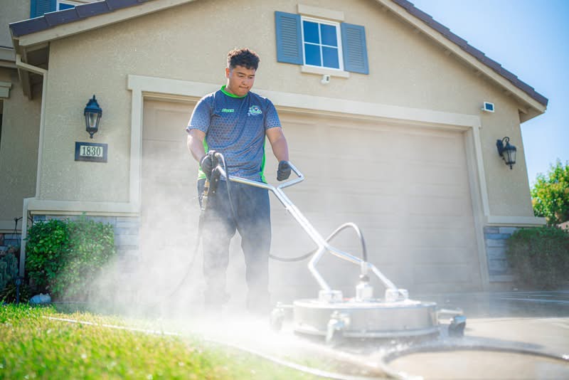 PureWash owner surface-cleaning a residential driveway in Los Banos